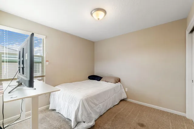 a bedroom with a bed and a dresser with mirror