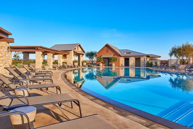 a view of a house with pool and chairs