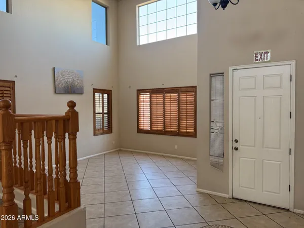 a view of a hallway with windows and stairs to living room