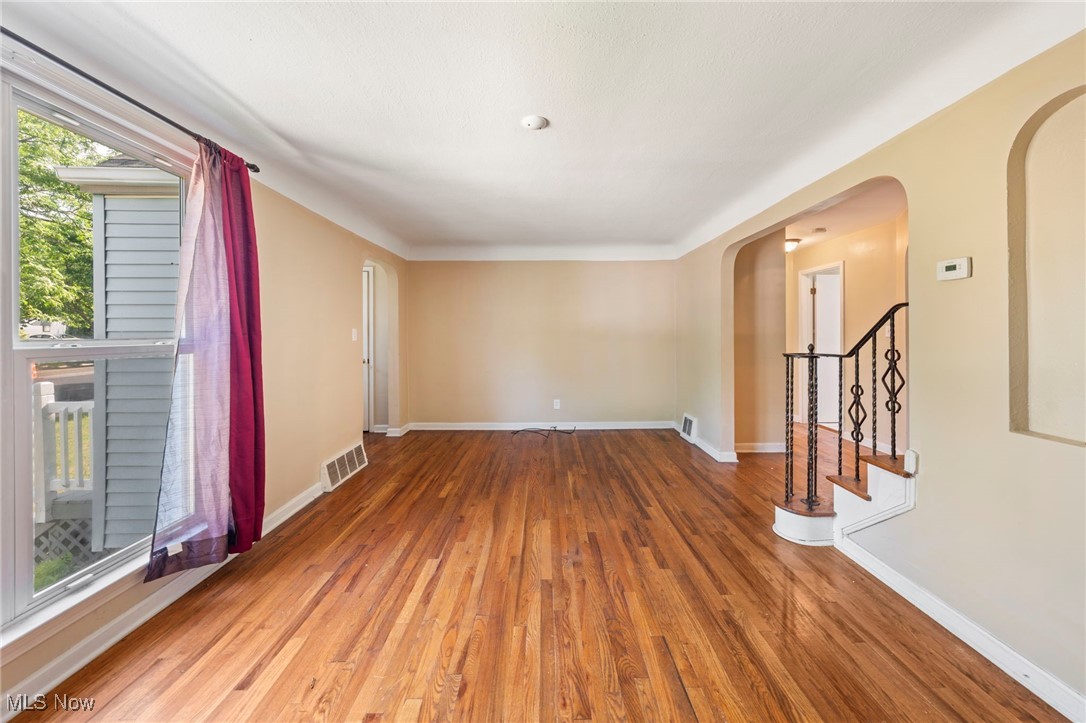 14804 Rockside Road Maple Heights, OH 44137 - Photo 20 of 44 Spare room featuring arched walkways, stairs, and wood finished floors