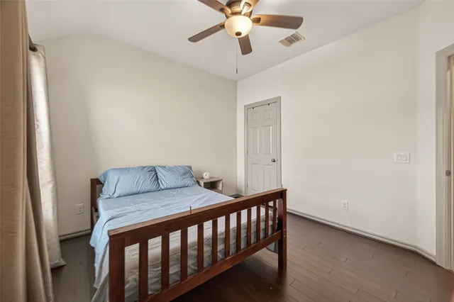 a bedroom with a bed and a chandelier fan
