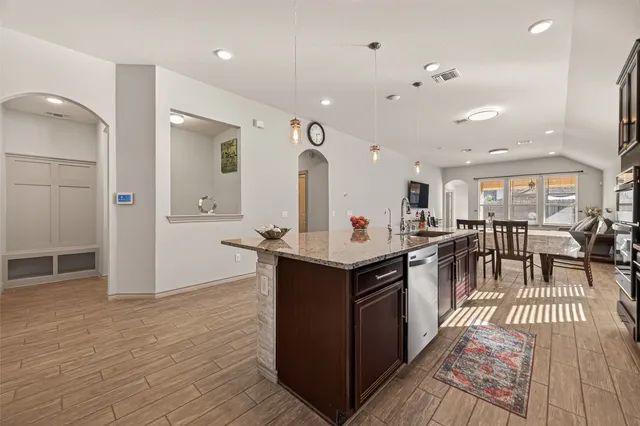 an open kitchen with kitchen island and a sink