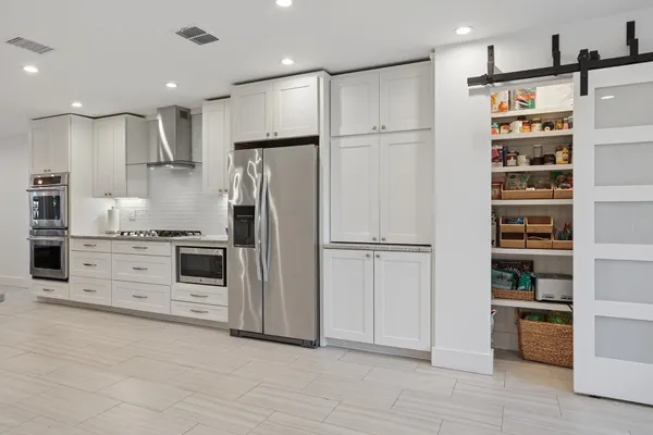 a kitchen with stainless steel appliances a refrigerator sink and cabinets