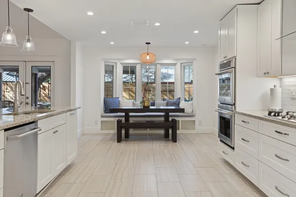 a kitchen with stainless steel appliances white cabinets and a refrigerator
