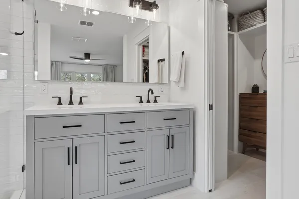 a bathroom with a double vanity sink toilet and shower