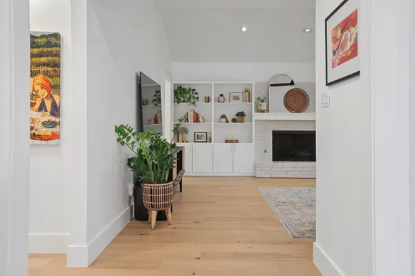 a view of a hallway with wooden floor and a potted plant