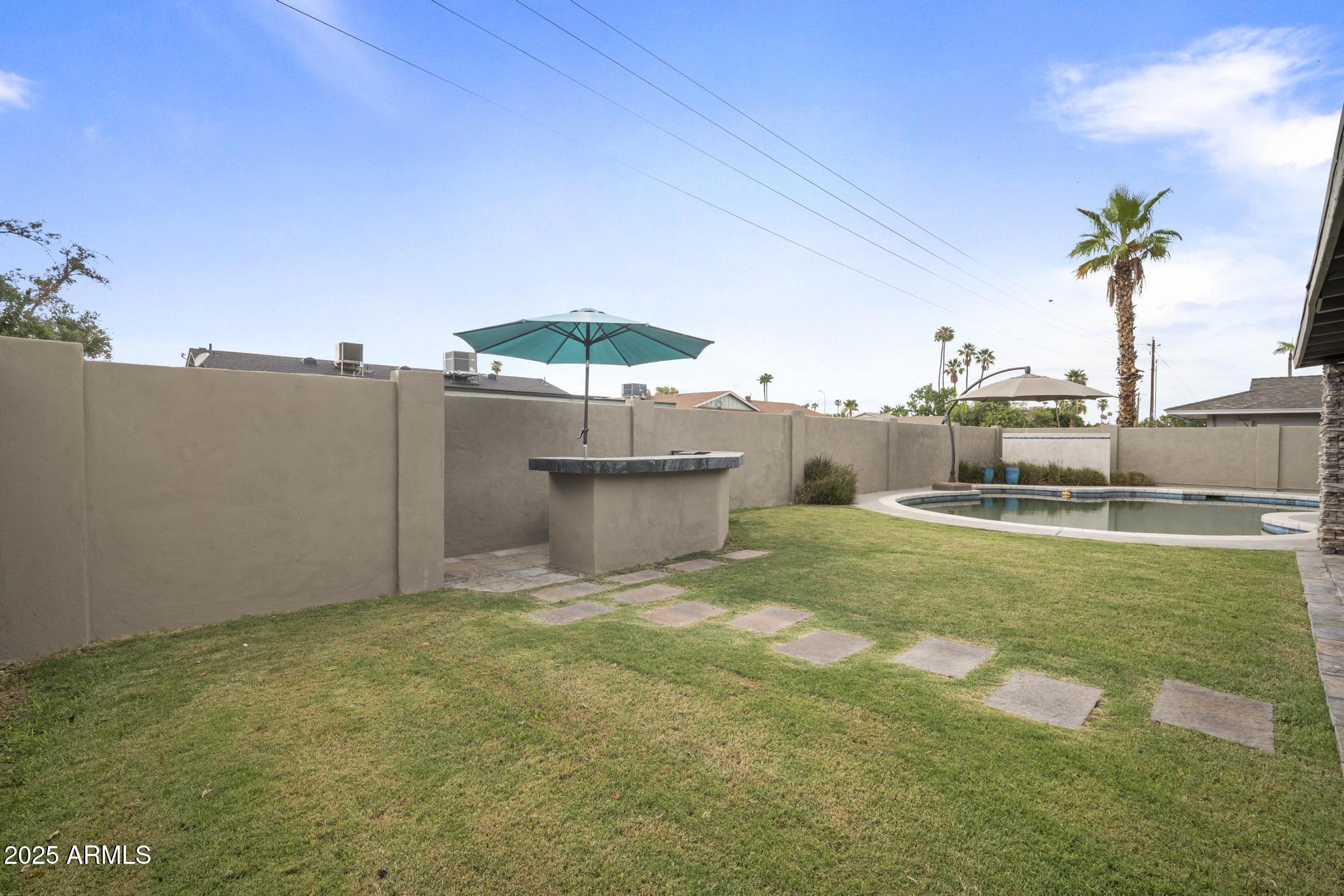3912 South Elm Street Tempe, AZ 85282 - Photo 32 of 33 a view of a patio with a table and chairs under an umbrella