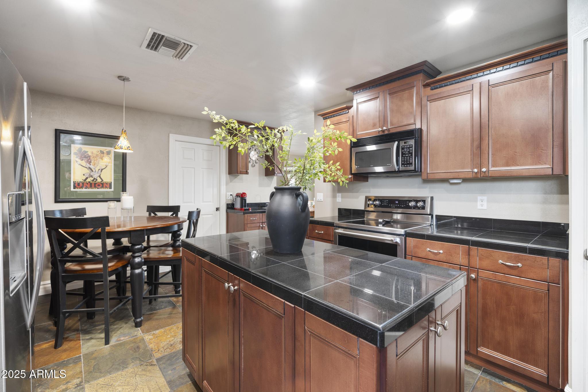 3912 South Elm Street Tempe, AZ 85282 - Photo 6 of 33 a kitchen with stainless steel appliances granite countertop a stove a sink a microwave and a refrigerator