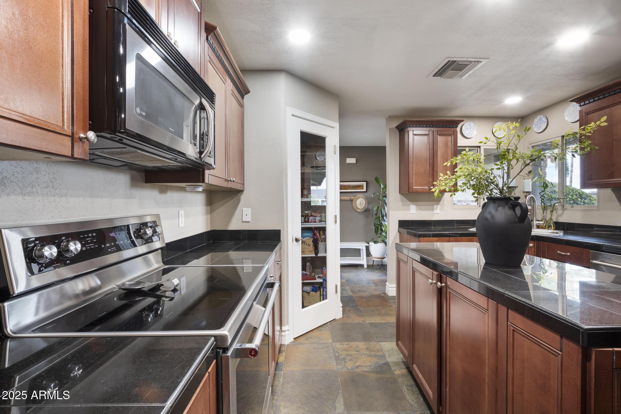 3912 South Elm Street Tempe, AZ 85282 - Photo 7 of 33 a kitchen with stainless steel appliances granite countertop a sink stove and cabinets