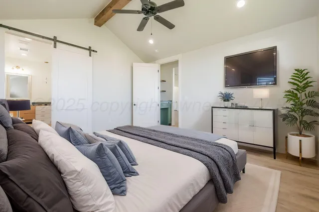 a bedroom with a bed and a flat screen tv