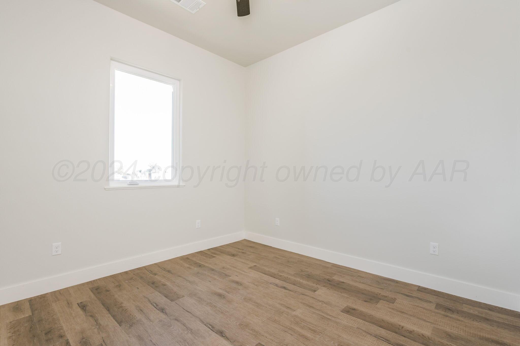 13351 Genevieve's Way Amarillo, TX 79118 - Photo 21 of 35 an empty room with wooden floor and windows