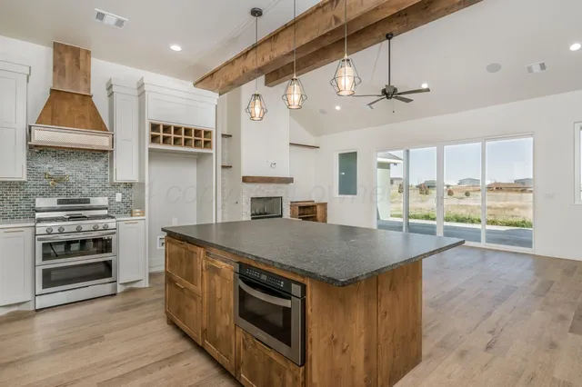 a kitchen with a stove and a wooden floor
