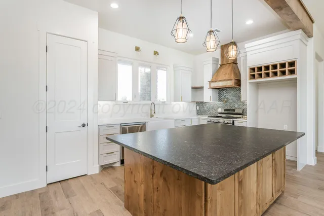 an open kitchen with a table chairs and a chandelier