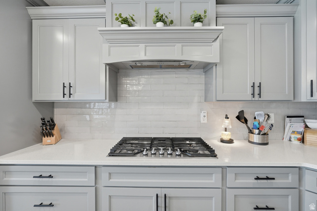 638 Canyon Rim Road Smithfield, UT 84335 - Photo 10 of 56 Kitchen featuring light stone counter tops, stainless steel gas stove top, and tile back splash