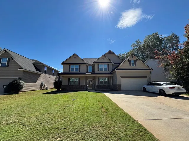 a view of a house with yard and porch