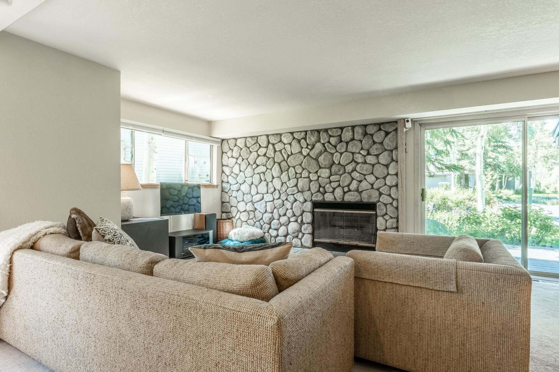 609 Golden Creek Road, Unit 609 Mammoth Lakes, CA 93546 - Photo 6 of 42 Stone-clad fireplace with a dark-framed firebox