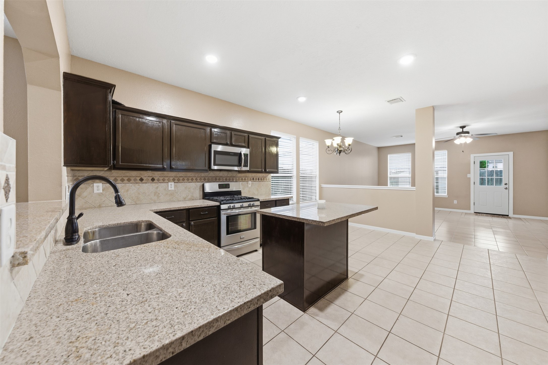 19710 Yaupon Ranch Drive Cypress, TX 77433 - Photo 18 of 34 a kitchen with stainless steel appliances granite countertop a sink a stove top oven a counter space and cabinets
