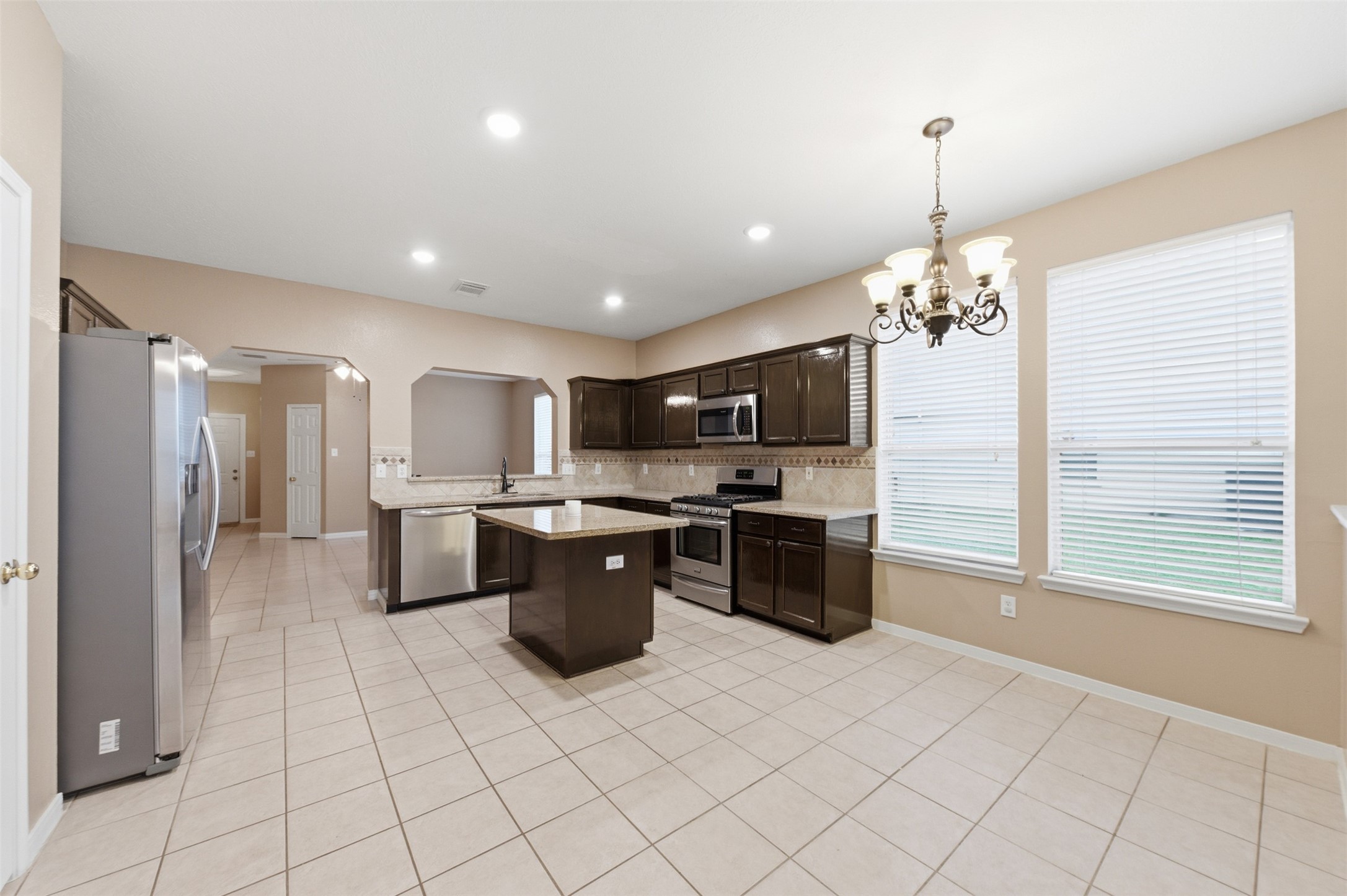 19710 Yaupon Ranch Drive Cypress, TX 77433 - Photo 19 of 34 a large kitchen with stainless steel appliances kitchen island granite countertop a refrigerator and a stove top oven