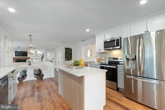 a kitchen with kitchen island a refrigerator stove and sink