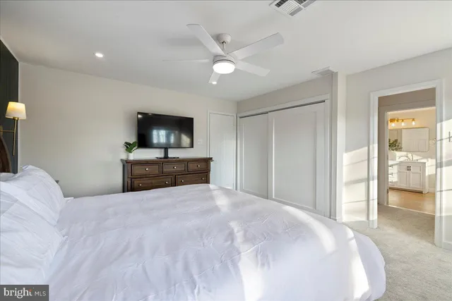 a large bedroom with a bed and a flat screen tv
