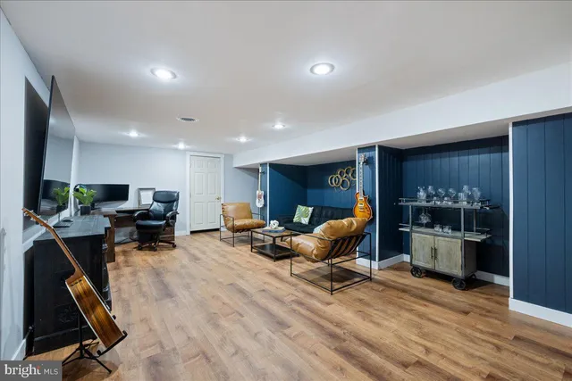 a living room with furniture gym equipment and a wooden floor