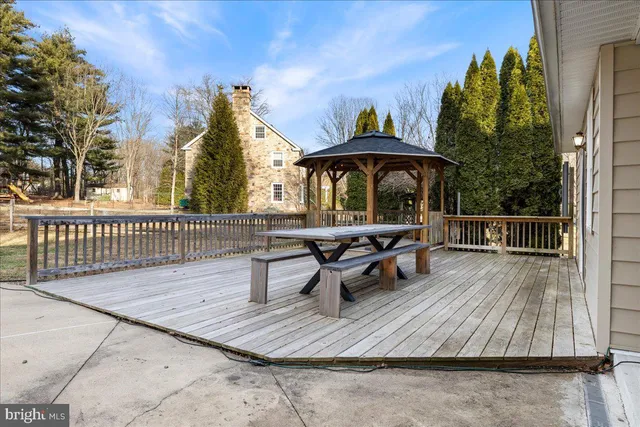 a view of a roof deck with table and chairs with wooden floor and fence