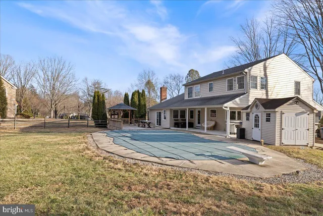 a view of a big house with a big yard and large trees
