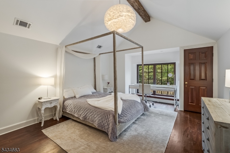 55 State Park Road Chester, NJ 07930 - Photo 17 of 48 a bedroom with a bed and a chandelier