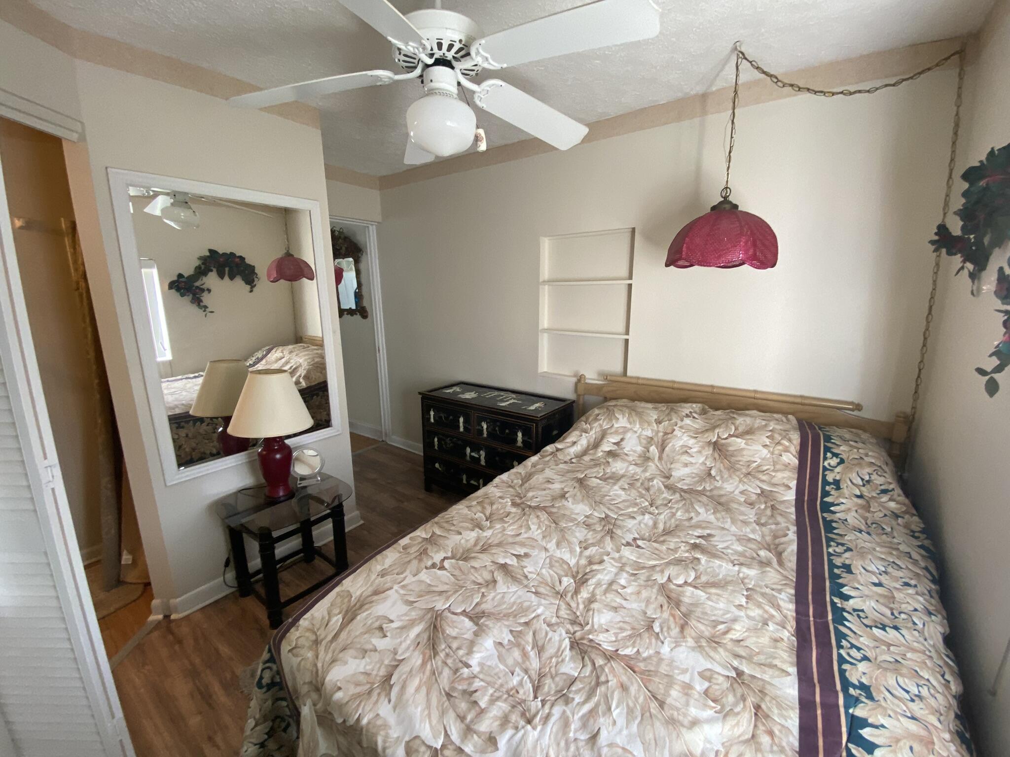 1101 25th Street Okeechobee, FL 34974 - Photo 8 of 28 a bedroom with a bed and a chandelier