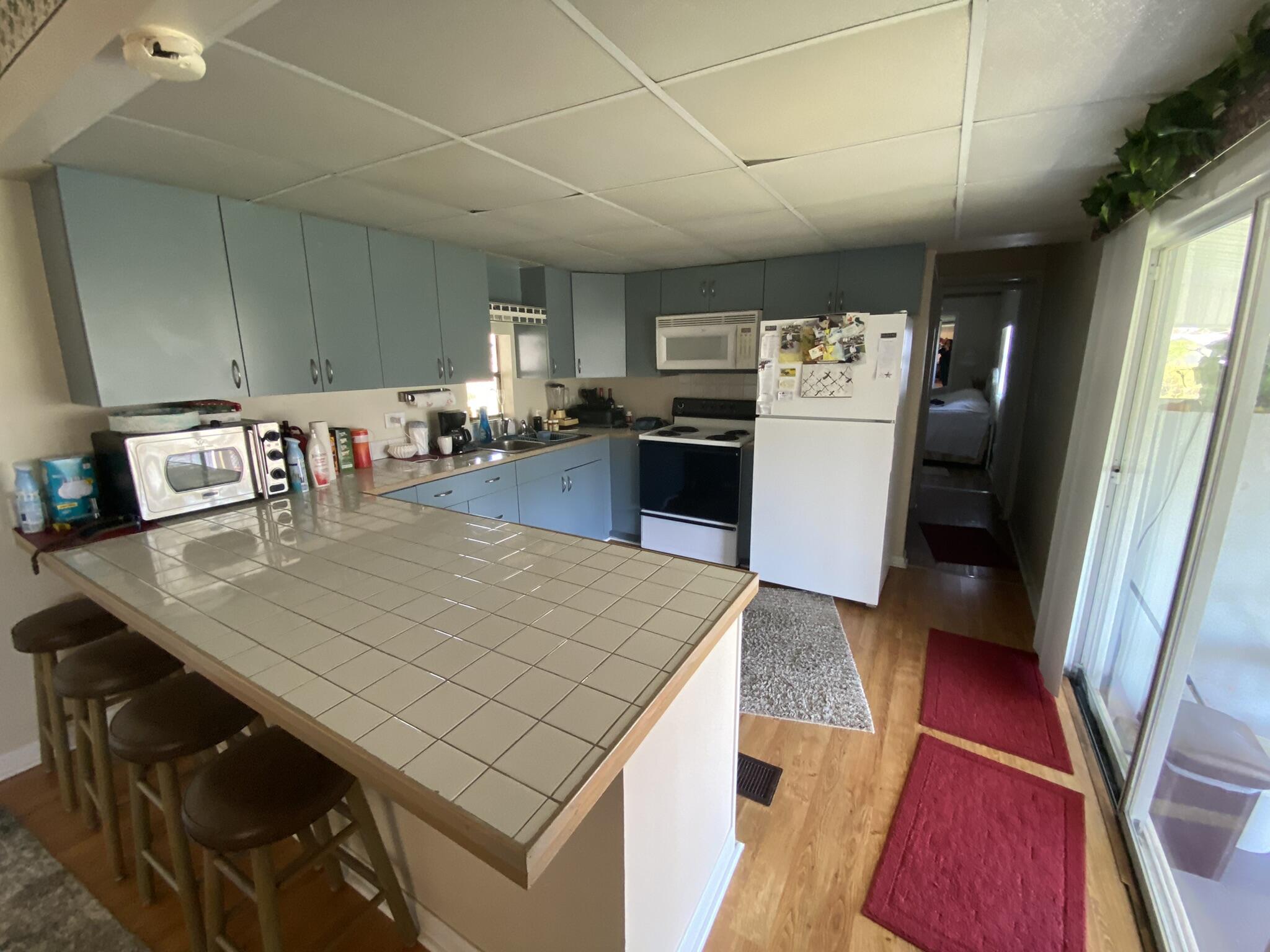 1101 25th Street Okeechobee, FL 34974 - Photo 10 of 28 a kitchen with stainless steel appliances granite countertop a table chairs and a refrigerator