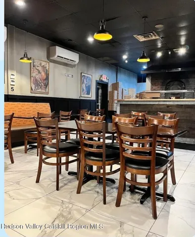 a kitchen with stainless steel appliances kitchen island granite countertop dining table chairs and a fireplace