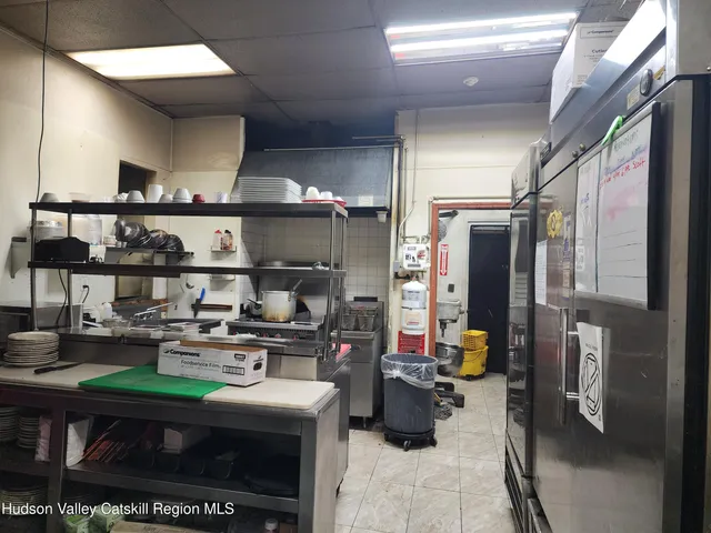 a room with stainless steel appliances kitchen island granite countertop a stove and a refrigerator