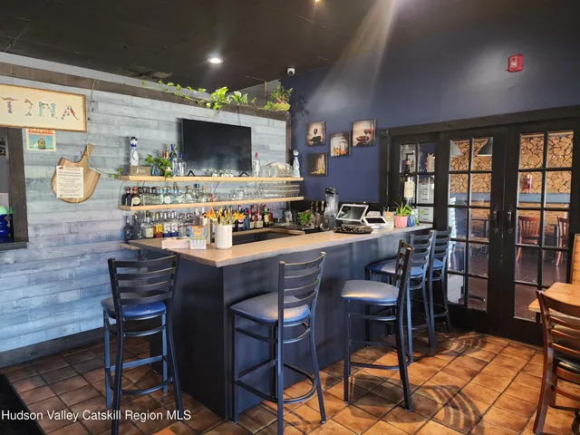 a room with stainless steel appliances kitchen island granite countertop a table chairs and a oven