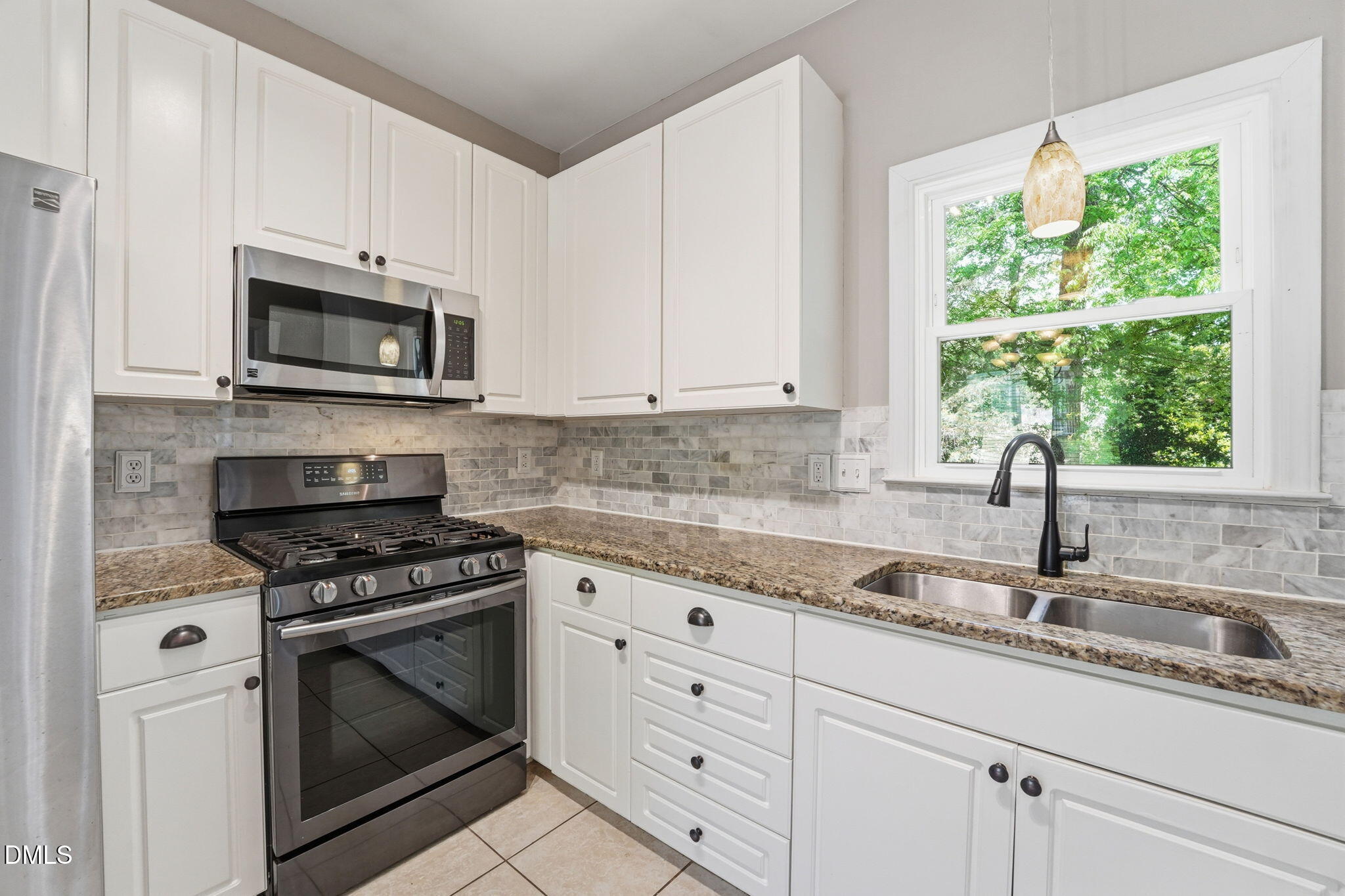 2201 Roswell Road Raleigh, NC 27615 - Photo 11 of 32 a kitchen with granite countertop white cabinets appliances and a window