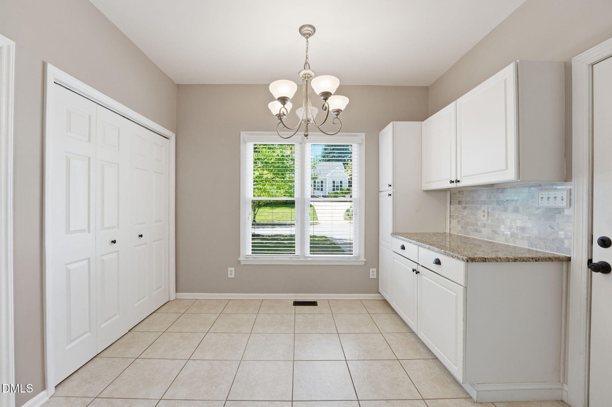 2201 Roswell Road Raleigh, NC 27615 - Photo 12 of 32 a kitchen with granite countertop white cabinets and window