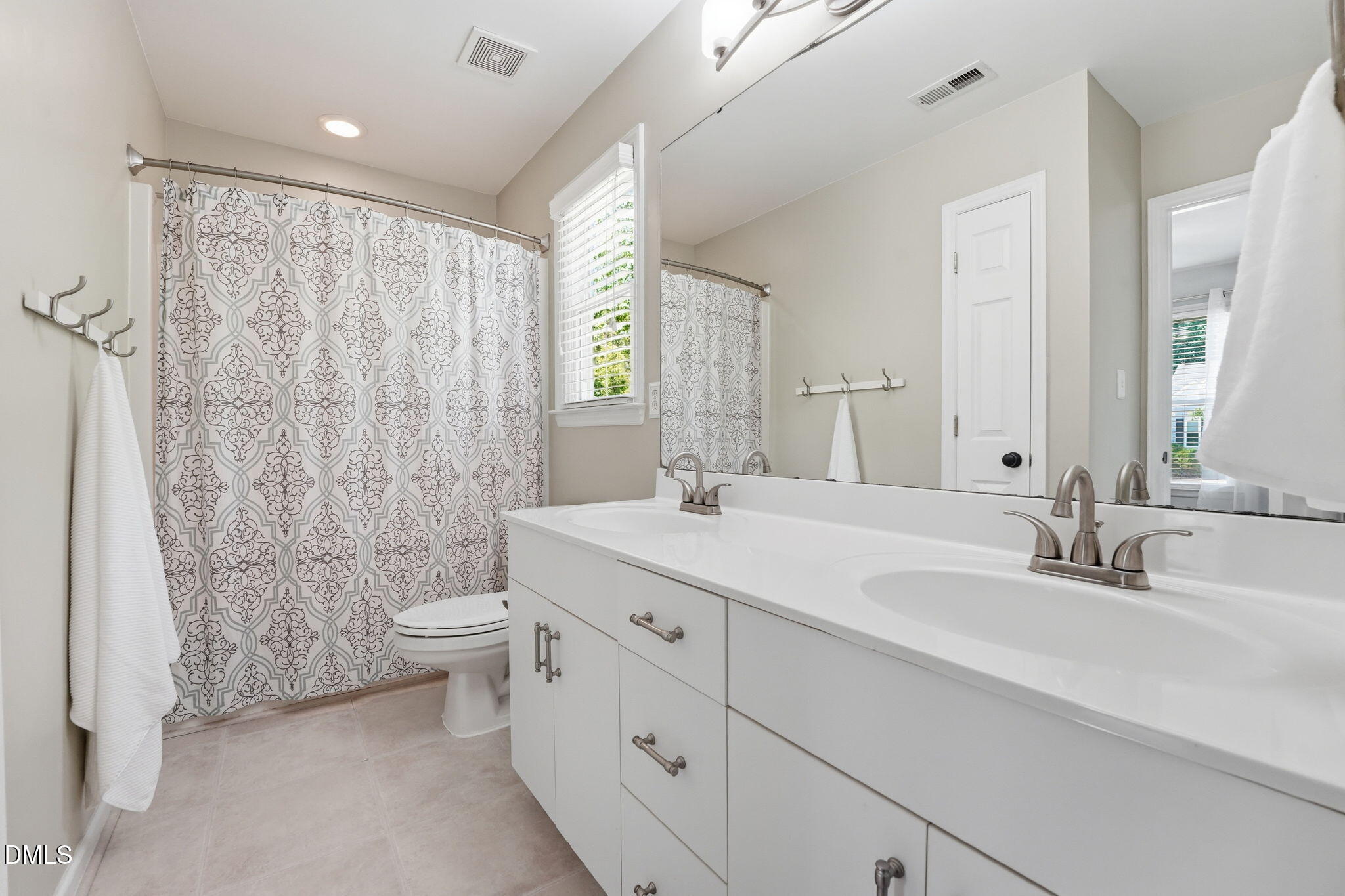 2201 Roswell Road Raleigh, NC 27615 - Photo 23 of 32 a bathroom with a double vanity sink toilet and a mirror
