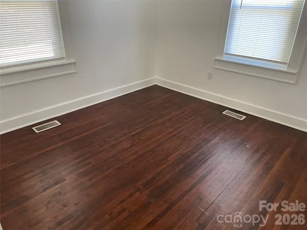 a view of a room with wooden floor and a window
