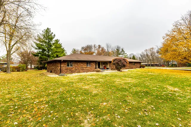 a front view of house with yard along with trees