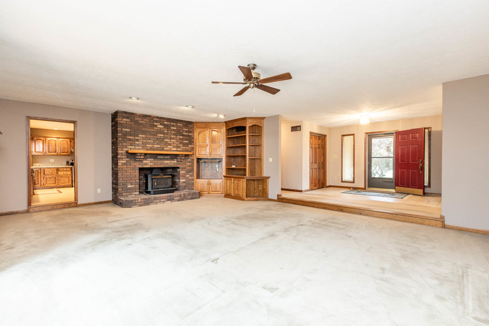 19051 Meander Way Bloomington, IL 61705 - Photo 6 of 30 an empty room with windows fireplace and a ceiling fan