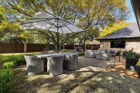 a view of a backyard with table and chairs under an umbrella