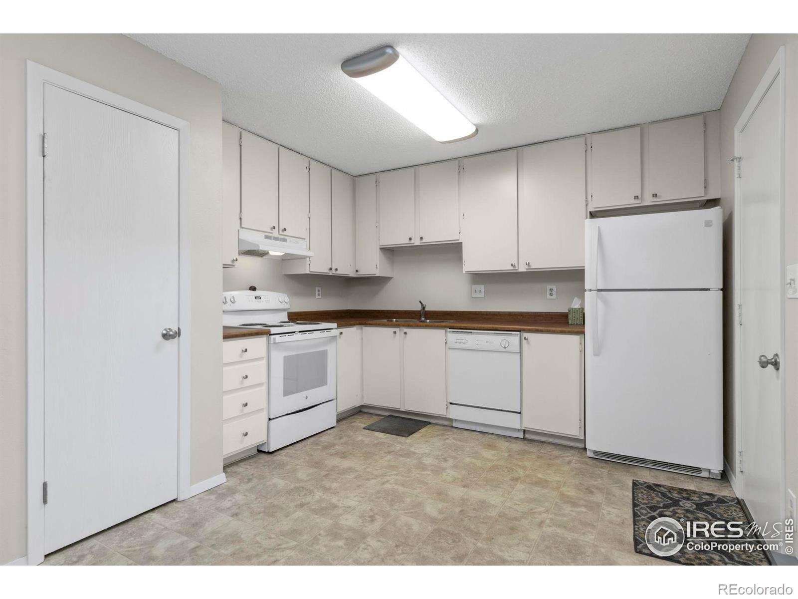 925 Columbia Road Fort Collins, CO 80525 - Photo 9 of 24 a kitchen with white cabinets and white appliances