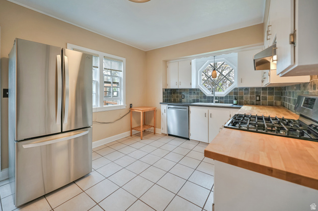 250 West 100 North Logan, UT 84321 - Photo 11 of 41 Kitchen featuring stainless steel appliances, white cabinets, tasteful backsplash, tile floors, and butcher block countertops