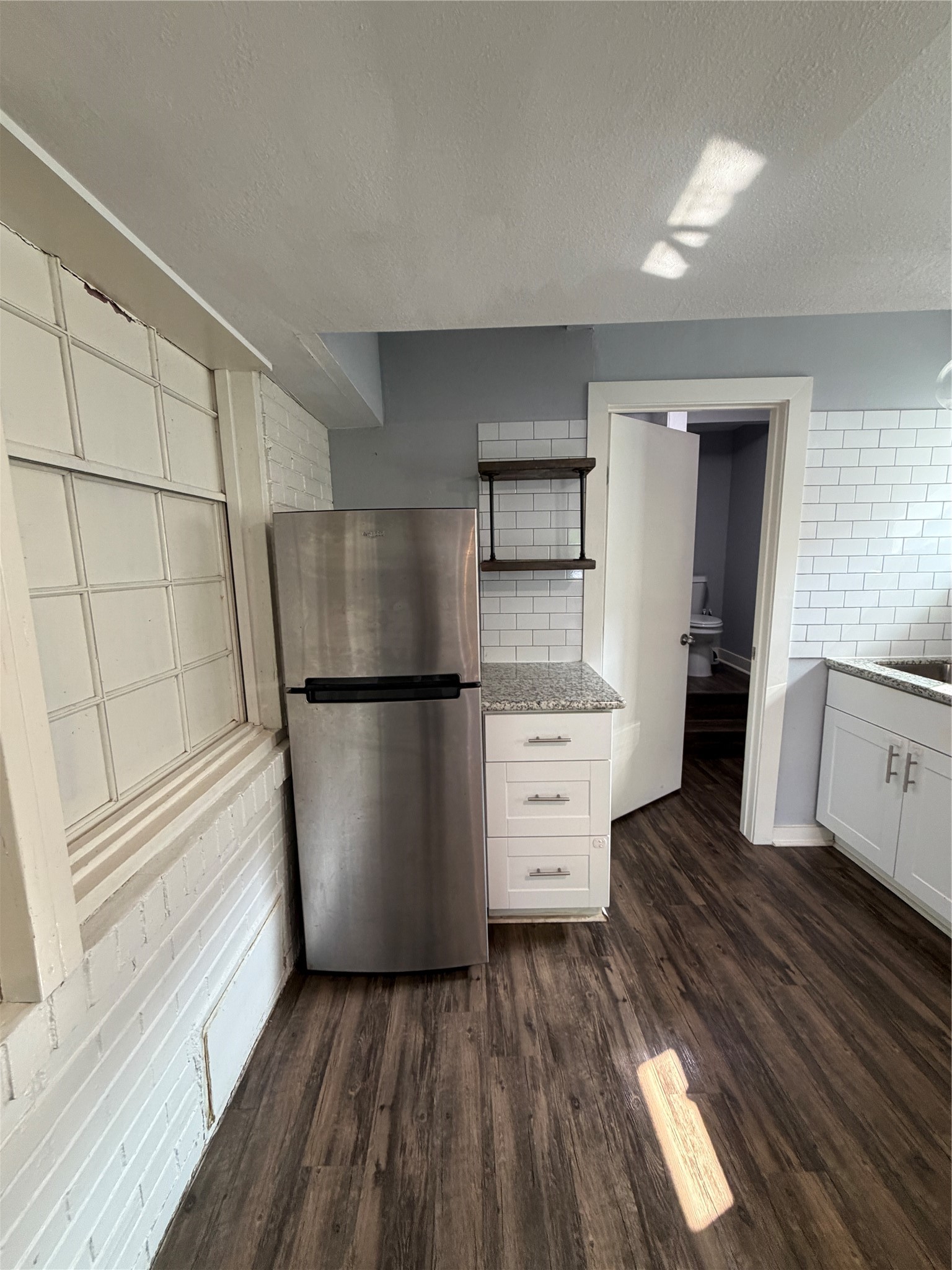 4630 Woodside Street, Unit 2 Houston, TX 77023 - Photo 4 of 11 a kitchen with a refrigerator and a stove top oven