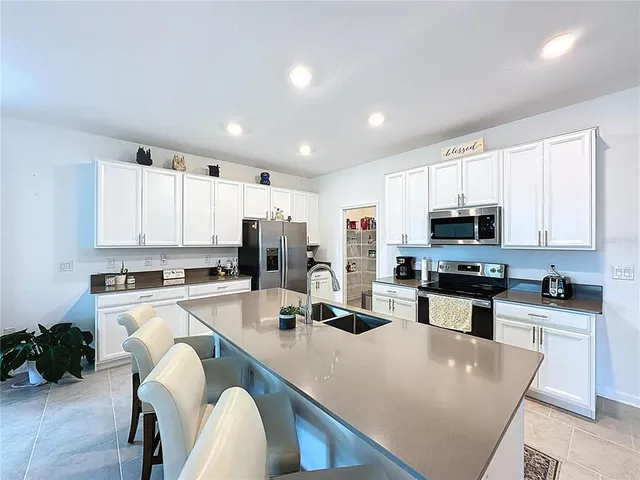 a kitchen that has a lot of cabinets a sink and a stove in it