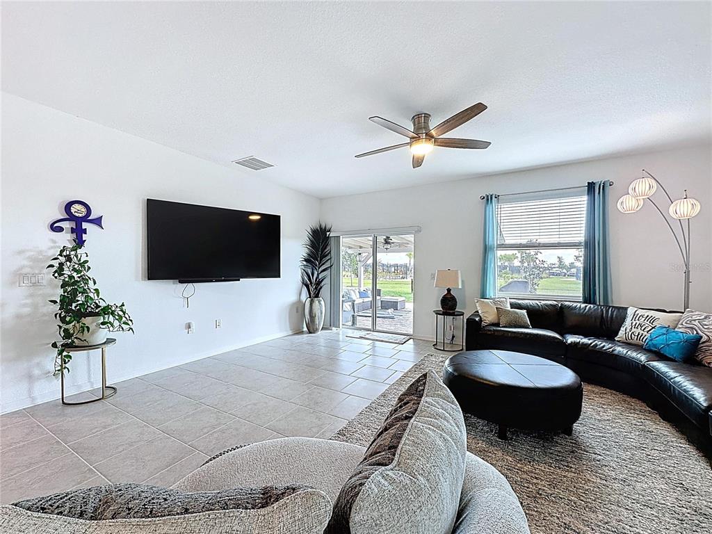 4190 Bull Street St. Cloud, FL 34772 - Photo 33 of 98 a living room with furniture a flat screen tv and a large window