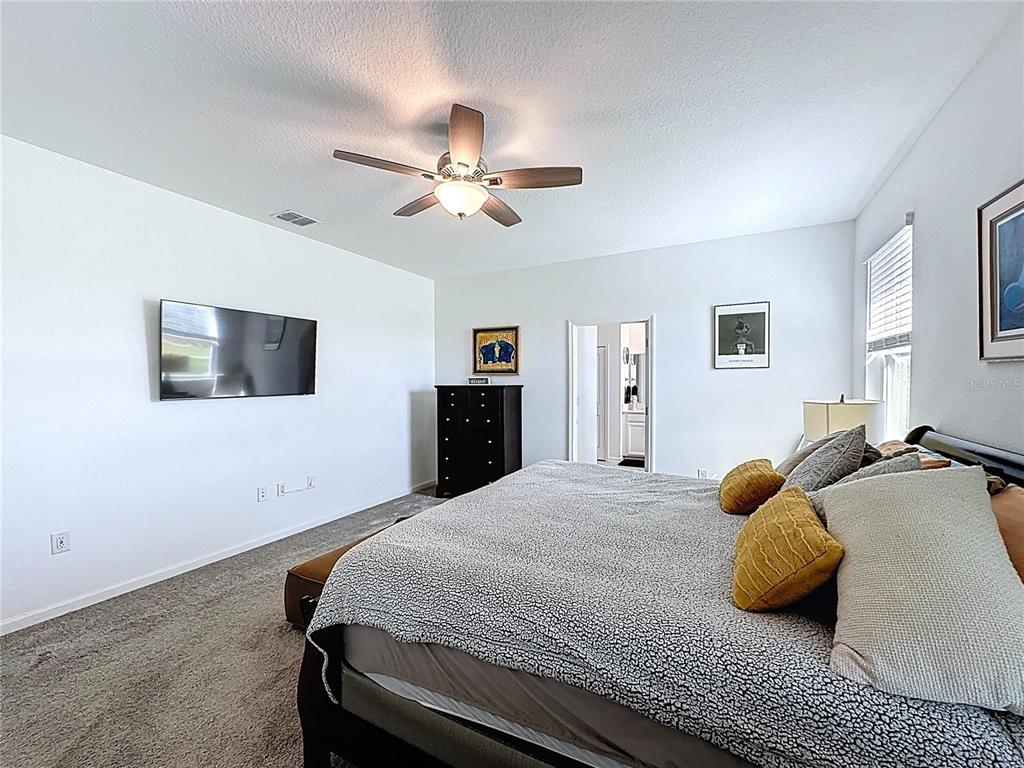 4190 Bull Street St. Cloud, FL 34772 - Photo 37 of 98 a bedroom with a bed and a flat screen tv