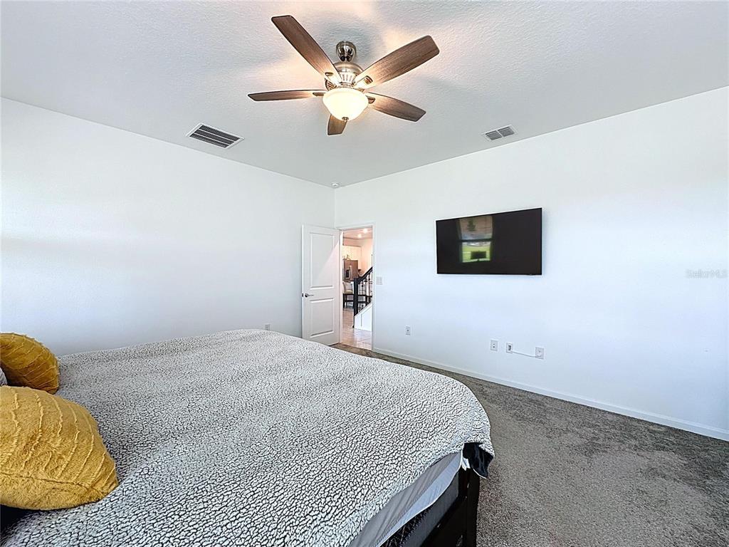 4190 Bull Street St. Cloud, FL 34772 - Photo 39 of 98 a bedroom with a bed and a ceiling fan