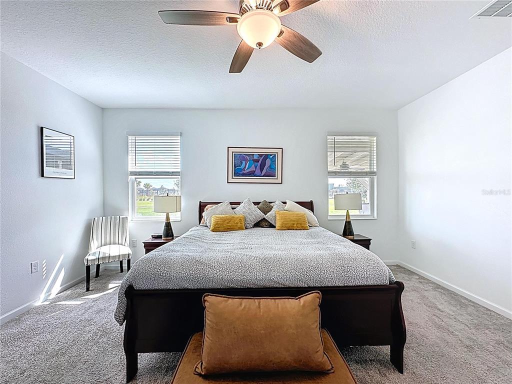 4190 Bull Street St. Cloud, FL 34772 - Photo 40 of 98 a bedroom with a bed and a chandelier