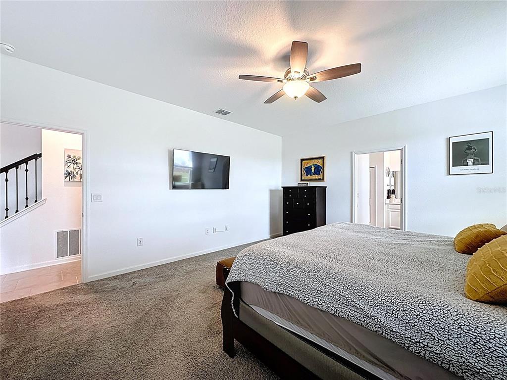 4190 Bull Street St. Cloud, FL 34772 - Photo 41 of 98 a bedroom with a bed and a chandelier