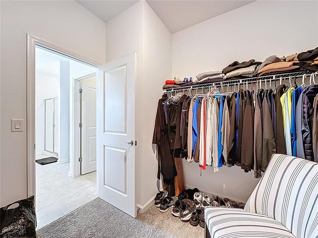 4190 Bull Street St. Cloud, FL 34772 - Photo 48 of 98 a view of walk in closet with clothes and shoes